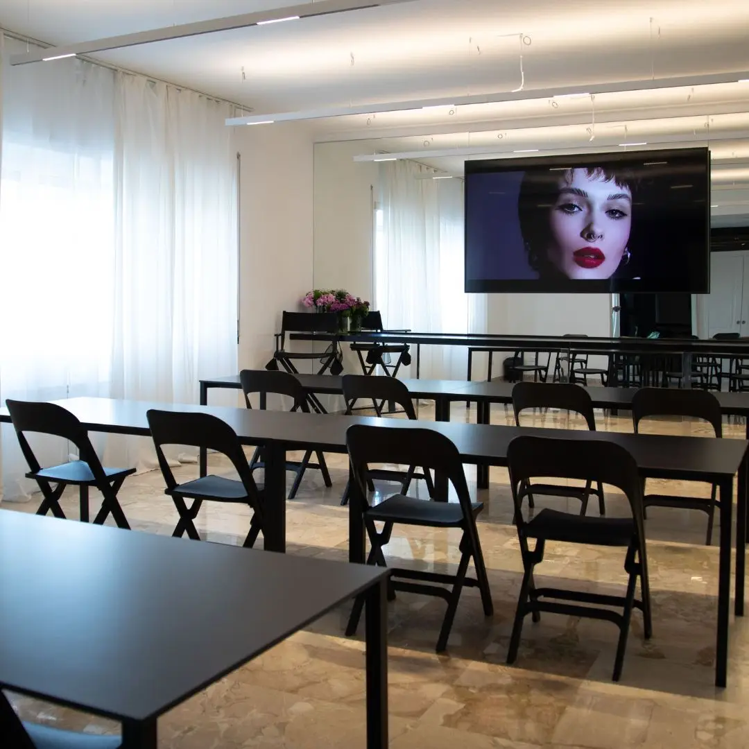 Aula corsi di Ego Space allestita con tavoli, sedie e grande schermo multimediale per masterclass di make-up